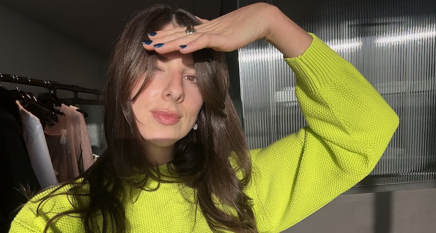Woman applying colour-refreshing hair product at home in bathroom